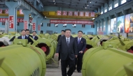 This undated picture released by North Korea's official Korean Central News Agency (KCNA) on December 26, 2025 shows North Korean leader Kim Jong Un (C) visiting major munitions industry enterprises to acquaint himself with the missile and shell production at an undisclosed place in North Korea. (Photo by KCNA VIA KNS / AFP) 