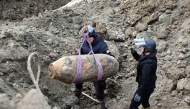 This handout photograph taken on December 28, 2025 and released by Serbia's Ministry of Interior, shows Serbian bomb disposal experts removing a 470-kg World War II aerial bomb, dropped on Nazi-occupied Belgrade in 1944, from a construction site in the Serbian capital. (Photo by Handout / Serbian Ministry of Interior Affairs / AFP) 