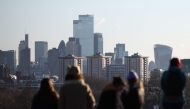 People look out at the view of the skyline of the financial office buildings in the City of London from Primrose Hill in London on January 2, 2026. Photo by HENRY NICHOLLS / AFP