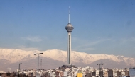 The Milad Tower is backdropped by the snow-covered Alborz Mountains, north of the capital Tehran on December 31, 2025. (Photo by Atta Kenare / AFP)
