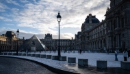 This photograph shows a general view of the Louvre Museum, with the Louvre pyramid (L) designed by Chinese-US architect Ieoh Ming Pei, after the first snowfall of the year in Paris on January 3, 2026. (Photo by Blanca CRUZ / AFP)
