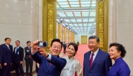 South Korea's President Lee Jae Myung (L) and his wife Kim Hea Kyung (2nd L) take a selfie with China's President Xi Jinping (2nd R) and his wife Peng Liyuan (R) after a dinner at the Great Hall of the People in Beijing on January 5, 2026. (Photo by YONHAP / AFP