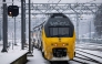 A train moves along a platform covered in snow, at Arnhem Central Station, as train service is resuming after an IT outage at the Dutch national railway service Nederlandse Spoorwegen (NS), on January 6, 2026. (Photo by Robin van Lonkhuijsen / ANP / AFP)