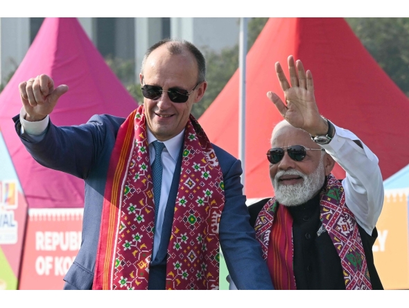 German Chancellor Friedrich Merz and Indian PM Narendra Modi wave to the crowd in Ahmedabad on January 12, 2026. (Photo by Shammi MEHRA / AFP)