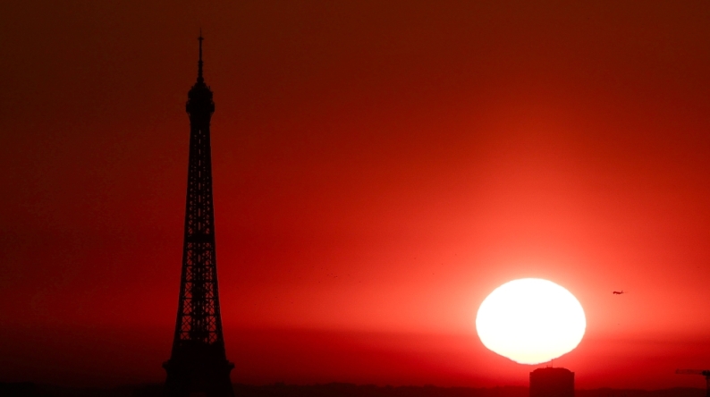 (Files) The sun rises by the Eiffel Tower in Paris on July 1, 2025. (Photo by Thibaud Moritz / AFP)
 