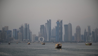 Tourists ride traditional boats along the corniche promenade in Doha on January 13, 2026. (Photo by Mahmud HAMS / AFP)
