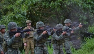 An Australian soldier (back L) supervises as Philippine Marines fire their weapons during a demonstration at Military Operation Urbanized Terrain (MOUTH) training exercises at the marine base in Ternate, Cavite province, southwest of Manila. File photo.