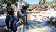 Natividad Martinez (R), mother of private Saul Pereira, visits his grave at the General Cemetery of the South in Caracas on January 18, 2026. (Photo by Pedro Mattey / AFP)