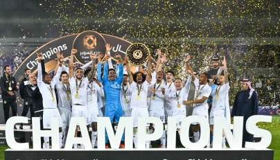 Akram Afif lifts the Super Shield as Al Sadd's players and officials celebrate their triumph.
