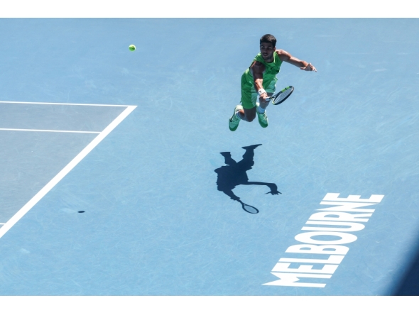 Spain's Carlos Alcaraz hits a return against USA's Tommy Paul during their men's singles match on day eight of the Australian Open tennis tournament in Melbourne on January 25, 2026. (Photo by Izhar Khan / AFP)