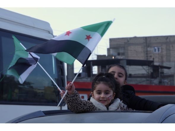 Children wave flags in Raqqa, northern Syria, January 21, 2026. (Str/Xinhua)