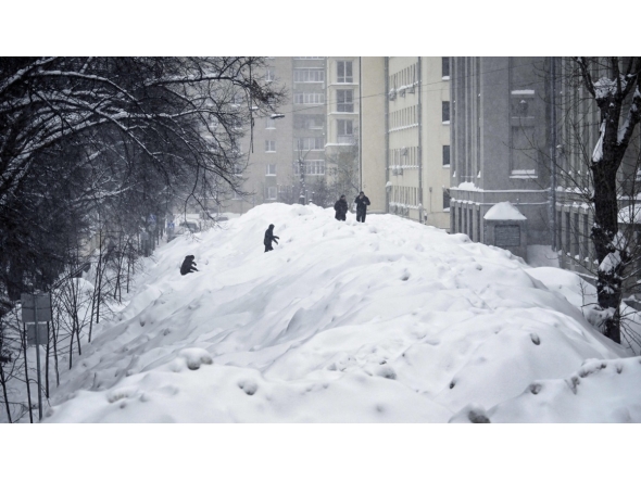 People cross a street used for temporary snow storage in central Moscow on January 29, 2026. (Photo by Alexander NEMENOV / AFP)
