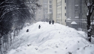 People cross a street used for temporary snow storage in central Moscow on January 29, 2026. (Photo by Alexander NEMENOV / AFP)
