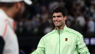 Spain's Carlos Alcaraz signs a television camera after beating Germany's Alexander Zverev in Melbourne on January 30, 2026. (Photo by Izhar Khan / AFP) 