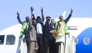Sudan Airways members of staff celebrate as they stand at the door of the first domestic flight arriving from Port Sudan, after it landed at Khartoum International Airport following a three-year hiatus, on February 1, 2026. (Photo by Ebrahim Hamid / AFP)
