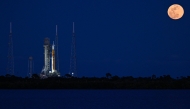 A full moon rises as the Space Launch System (SLS) rocket and the Orion spacecraft, integrated for the Artemis II mission, are seen at the Kennedy Space Center, on February 1, 2026. (Photo by Miguel J. Rodriguez Carrillo / AFP)
 
