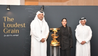 Chairman of Media City Qatar H E Sheikh Dr. Abdulla bin Ali Al-Thani (left), CEO of Media City Qatar Hamad Omar A Al-Mannai (right), and artist Yasamin Shaikhi with her winning artwork 'The Loudest Grain'.