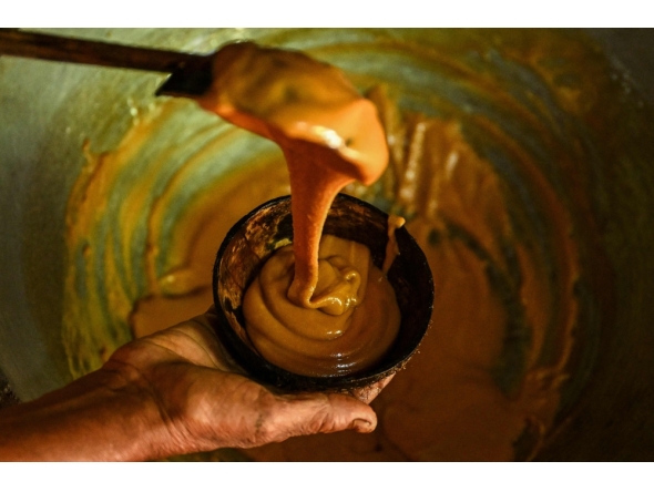 Sarath Ananda, a kithul tapper serving freshly-made jaggery from the kithul sap, at Ambegoda village in southern Sri Lanka. (Photo by Ishara S. Kodikara / AFP) /