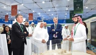 UDST President Dr. Salem Al-Naemi at the University's booth with other officials and participants. 