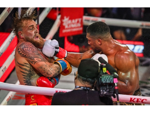 S boxer and influencer Jake Paul (L) and British boxer Anthony Joshua fight in a non-title heavyweight bout at the Kaseya Center in Miami, Florida on December 19, 2025. The two men fought in a controversial Netflix-backed bout in December, where Joshua made hard work of defeating his vastly less accomplished opponent. (Photo by Giorgio Viera/ AFP)