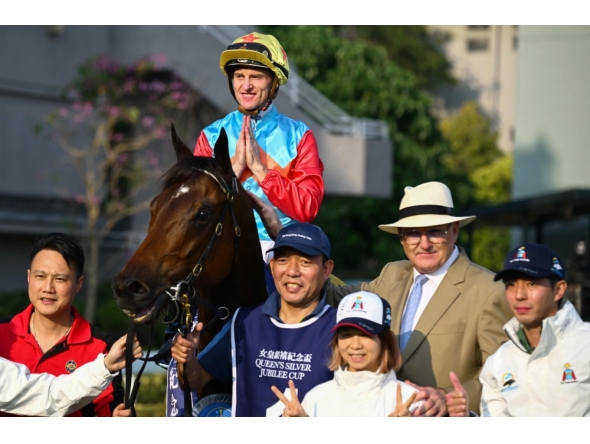 Ka Ying Rising with jockey Zac Purton and trainer David Hayes (2nd R) pose with others after victory in the Queen's Silver Jubilee Cup horse race at Sha Tin Racecourse in Hong Kong on February 22, 2026. (Photo by Peter Parks / AFP)