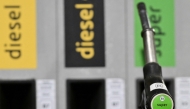 A person holds a petrol pump to fill up the car with gazole at an Eni petrol station near Monza, northern Italy on March 11, 2026. (Photo by Stefano Rellandini / AFP)