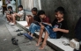 Children play online games against each other on smartphones and tablets along an alley in Jakarta on March 26, 2026. Photo by YASUYOSHI CHIBA / AFP