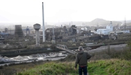 A tourist walks down a slag heap next to abandoned steel plants in Charleroi, southern Belgium, on March 11, 2026. (Photo by Nicolas Tucat / AFP)
