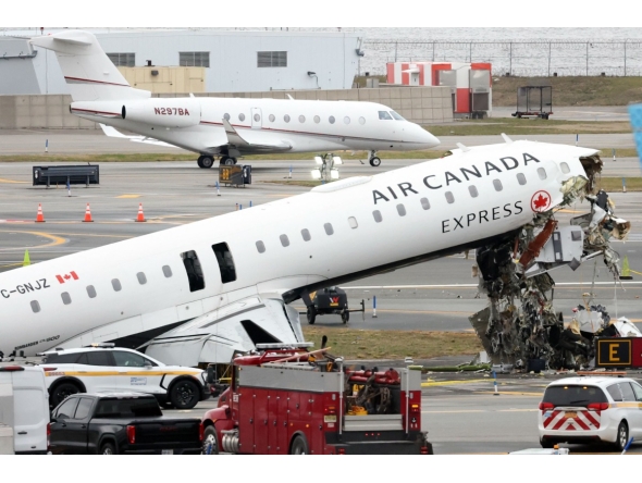 An executive jet taxis behind the Air Canada Express CRJ-900 that collided with a Port Authority fire truck at LaGuardia Airport in New York, after the airport resumed operations on March 23, 2026. Photo by TIMOTHY A. CLARY / AFP