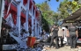Police officers look at a building of the North Sumatra's National Sports Committee of Indonesia (KONI) damaged following a severe 7.4-magnitude offshore quake in Manado, North Sulawesi on April 2, 2026. (Photo by Tonny Rarung / AFP)