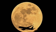 Air China cargo's airline Boeing 777-FFT aircraft flies past the April full moon in Frankfurt am Main, western Germany on April 1, 2026. (Photo by Kirill Kudryavtsev / AFP)