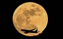 Air China cargo's airline Boeing 777-FFT aircraft flies past the April full moon in Frankfurt am Main, western Germany on April 1, 2026. (Photo by Kirill Kudryavtsev / AFP)