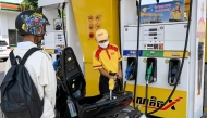 An employee pumps gasoline into the motorbike of a customer at a fuel station in Phnom Penh on April 1, 2026. (Photo by Tang Chhin Sothy / AFP)