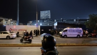 Police officers stand guard at the entrance of the Alejandro Villanueva Stadium while relatives wait for news after an accident in the stands in Lima on April 3, 2026. (Photo by Connie FRANCE / AFP)