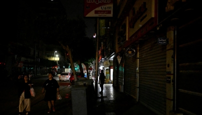 People walk past a closed cinema as shops close early under a government-ordered curfew aimed at reducing energy costs in downtown Cairo on April 2, 2026. Photo by KHALED DESOUKI / AFP