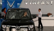 This photo taken on April 11, 2026, shows a woman behind the wheel of a car inside a Vinfast electric car dealership in Hanoi. (Photo by Nhac Nguyen / AFP)