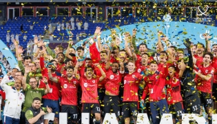 Al Rayyan players and officials celebrate with the trophy.