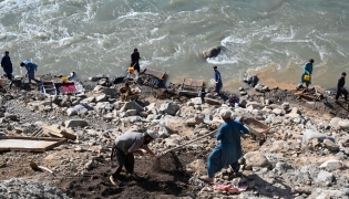 This photograph taken on April 13, 2026 shows Afghan men digging a mountainside along the Kunar riverbed before seiving stones in search of gold nuggets in the Song area of Ghaziabad district, Kunar province. (Photo by Wakil Kohsar / AFP)