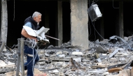 A man carries a machine he salvaged from the rubble of a destroyed building after returning to the southern Lebanese city of Nabatieh on April 20, 2026. (Photo by Mahmoud ZAYYAT / AFP)