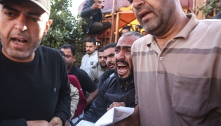 A Palestinian man reacts as he and others carry the body of a victim at the Nasser Hospital following an Israeli airstrike in the city of Khan Yunis, in the southern Gaza Strip on April 21, 2026. (Photo by Bashar Taleb / AFP)