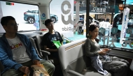 Visitors try out a WeRide autonomous vehicle at the Beijing Auto Show in Beijing on April 26, 2026. (Photo by Greg Baker / AFP)
