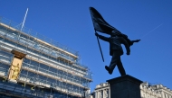 A statue (R) which suddenly appeared the day before, bearing the signature of British street artist Banksy etched onto its base, is pictured in Waterloo Place in central London early morning on April 30, 2026. Photo by Richard A. Brooks / AFP