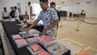Indonesian police display evidence before authorities held a press conference following the arrest of dozens of suspects in an online fraud case in Surabaya (Photo by Juni Kriswanto / AFP)