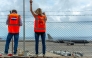 Representatives from the Netherlands embassy wave as a plane bound for the Netherlands carrying passengers evacuated from the Dutch-flagged hantavirus-stricken cruise ship MV Hondius prepares to take off from the Tenerife Sur-Reina Sofia airport on the island of Tenerife in Spain's Canary Islands on May 10, 2026. (Photo by Antonio Sempere / AFP)
