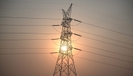 (Files) This file photo taken on April 16, 2026 shows the sun setting next to power lines along San Fernando town, Pampanga province, north of Manila. (Photo by Ted Aljibe / AFP)