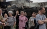 Local residents stand by a damaged shopping center following Russian strikes in Kyiv on May 25, 2026. (Photo by Tetiana Dzhafarova / AFP)