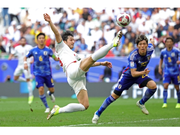 (FILES) Iran's forward #20 Sardar Azmoun shoots the ball past Japan's defender #22 Takehiro Tomiyasu during the Qatar 2023 AFC Asian Cup quarter-final football match between Iran and Japan at Education City Stadium in al-Rayyan, west of Doha, on February 3, 2024. (Photo by Giuseppe Cacace / AFP)