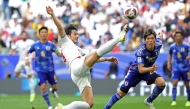(FILES) Iran's forward #20 Sardar Azmoun shoots the ball past Japan's defender #22 Takehiro Tomiyasu during the Qatar 2023 AFC Asian Cup quarter-final football match between Iran and Japan at Education City Stadium in al-Rayyan, west of Doha, on February 3, 2024. (Photo by Giuseppe Cacace / AFP)