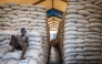 (Files) A worker sits atop sacks of food aid in a hangar at a World Food Programme (WFP) warehouse in Bor, Jonglei State, on February 13, 2026. (Photo by Luis Tato / AFP)
 