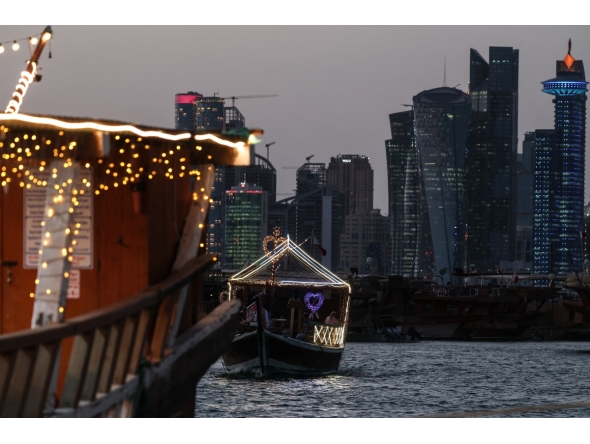 Traditional wooden boats are pictured against the backdrop of illuminated skyscrapers along the Corniche promenade in Doha on May 31, 2026. (Photo by Karim JAAFAR / AFP)
